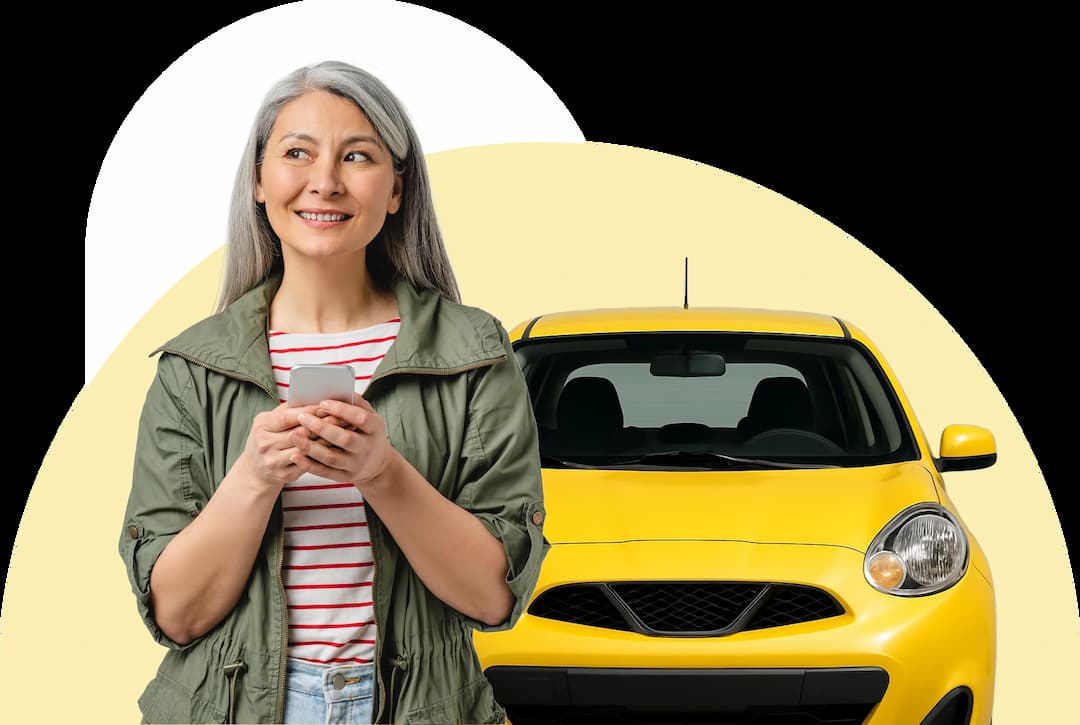 Smiling woman stands happily next to a yellow car